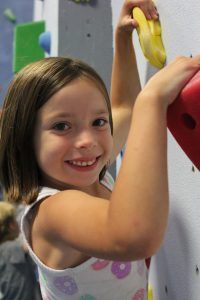 girl with brown hair rock climbing