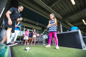 girl golfing with coach